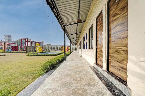 a building with a walkway next to a field at Hotel O New Friends Hotel in Prayagraj