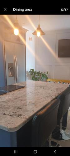 a kitchen with a granite counter top with two chairs at Dunfolan House in Dundrum