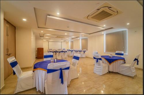 a banquet hall with tables and chairs and a chalkboard at Hotel Bhaskar-Near Jaipur Airport in Jaipur