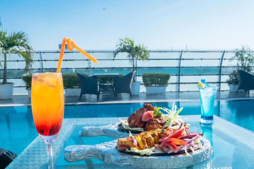 a plate of food on a table next to a drink at Hotel Bhaskar-Near Jaipur Airport in Jaipur
