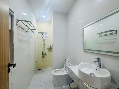a white bathroom with a sink and a toilet at Lighthouse Hotel & Apartment Phan rang in Kinh Dinh