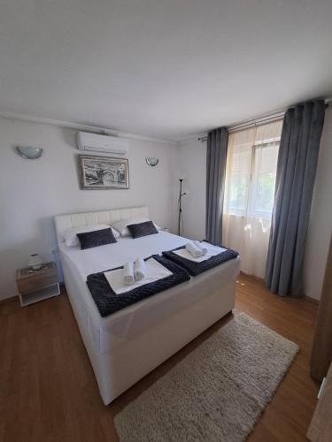 a bedroom with a large white bed with a rug at Villa Panorama Blagaj in Blagaj