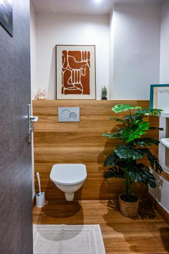 a bathroom with a toilet and a plant at Hôtel Le Montmartre Saint Pierre in Paris
