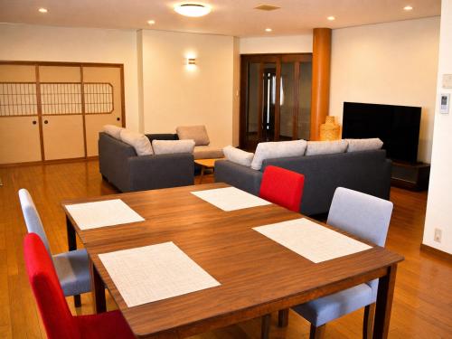 a living room with a wooden table and chairs at Sumomo in Takayama