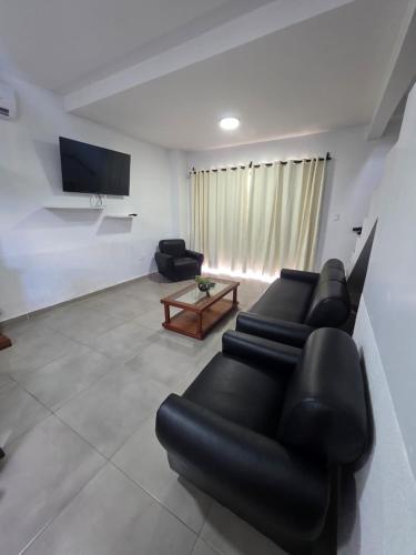 a living room with black leather furniture and a flat screen tv at Duplex en Luque in Zarate Isla