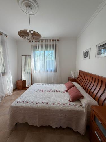 a bedroom with a large bed with red pillows at Chalet privado playa de Boa in Noya