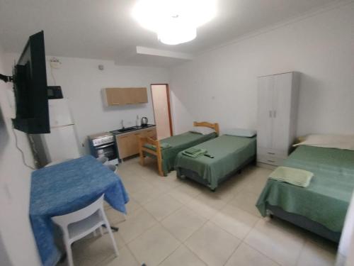 a room with two beds and a kitchen with a sink at Aprt Belgrano 658 in Neuquén