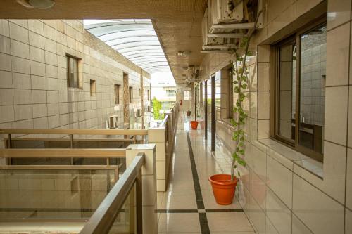ein leerer Flur eines Gebäudes mit einer Topfpflanze in der Unterkunft Hotel Djigui in Abidjan