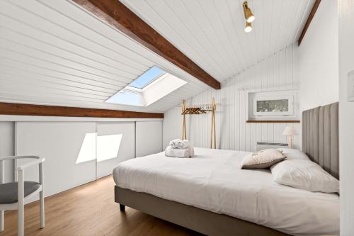 a bedroom with a large bed and a skylight at Villa Miroir in Publier