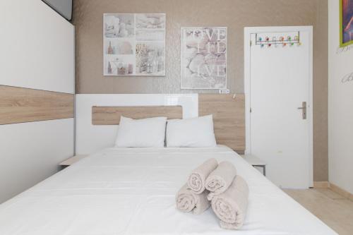 a bedroom with a white bed with towels on it at Casa Lori Albufeira in Albufeira
