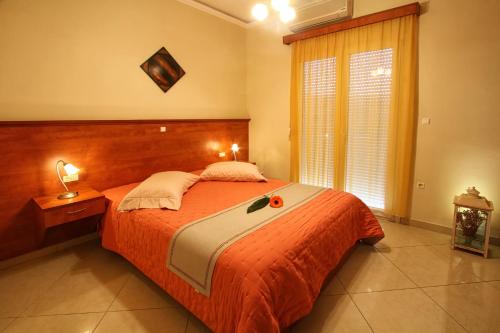 a bedroom with a large bed with an orange blanket at Porto Limnia in Volissos