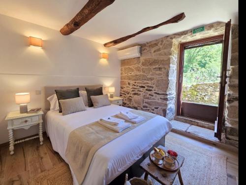 a bedroom with a large bed and a window at Casa Rio D'Além in Melgaço