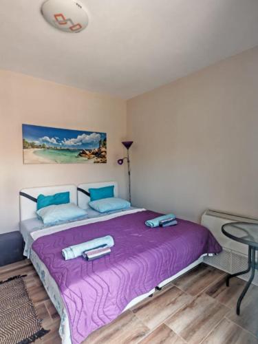 a bedroom with a large purple bed with a table at Villa Yulia in Luštica