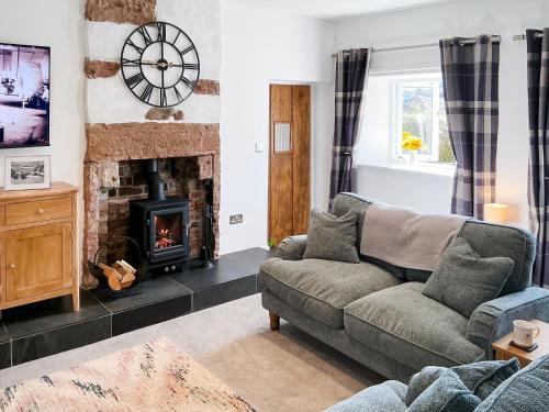 a living room with a couch and a fireplace at Abbey Cottage in St Bees