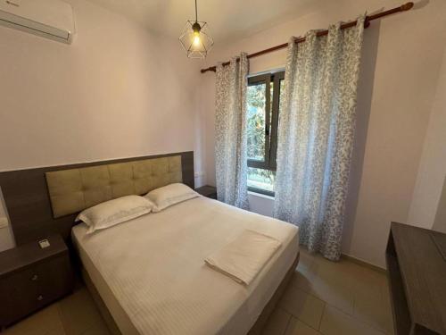 a bedroom with a large bed and a window at 07 Apartment Vlore in Vlorë