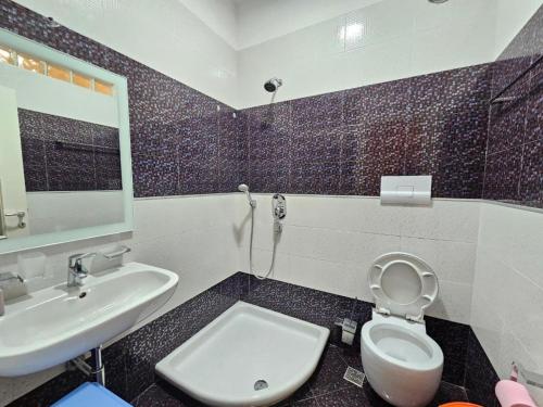 a bathroom with a sink and a toilet and a mirror at 07 Apartment Vlore in Vlorë