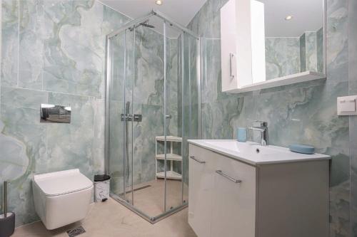 a bathroom with a shower and a toilet and a sink at Local View Apartments in Polychrono