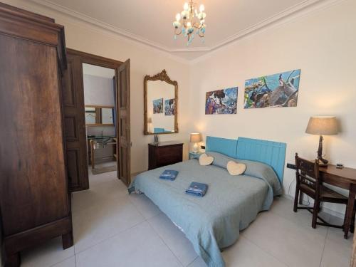 a bedroom with a blue bed with a desk and a mirror at La chambre de Jeanne in Toul