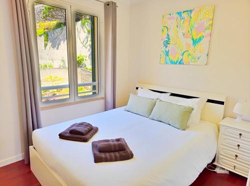 a bedroom with a large white bed with towels on it at Dorisol Vista Formosa by Rentallido in Funchal