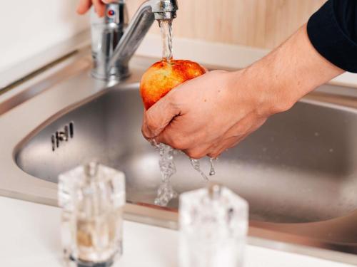 a person holding an apple with water dripping from a sink at Ibis Styles Charleroi Airport Aero 44 in Charleroi