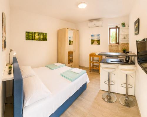 a small room with a bed and a kitchen at Apartments Mohar II in Baška