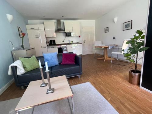 a living room with a blue couch and a kitchen at Ferienwohnung Meding am See in Schondorf am Ammersee