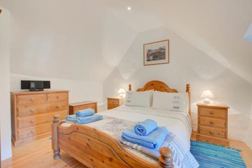 a bedroom with a wooden bed with towels on it at 1 Bed in Ruan Minor oc-rencot in Ruan Minor