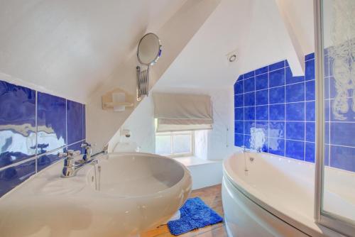 a large bathroom with a tub and a mirror at 1 Bed in Ruan Minor oc-rencot in Ruan Minor