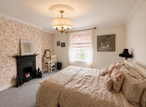 a bedroom with a bed and a fireplace and a chandelier at 5 Bed in Hundleby oc-o44769 in Spilsby