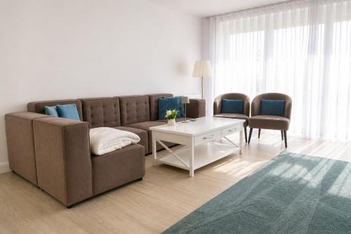 a living room with a couch and a table and chairs at Heidetraum - Modernes Ferienhaus in der Lüneburger Heide in Soltau
