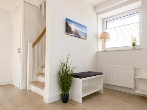 a white staircase with a bench and a plant at Heidetraum - Modernes Ferienhaus in der Lüneburger Heide in Soltau