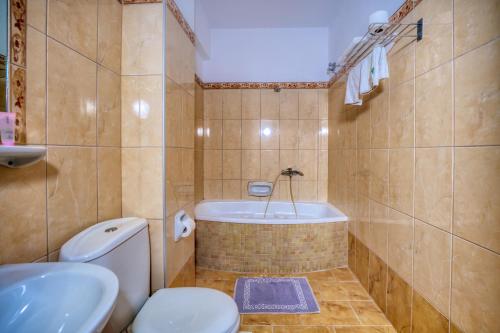 ein Badezimmer mit Badewanne, Toilette und Waschbecken in der Unterkunft Sunset Hotel in Korfu-Stadt