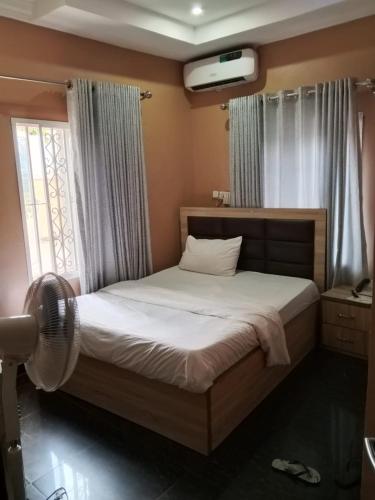 a bedroom with a bed and a window at Clover Apartments and suites in Abuja