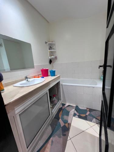 a bathroom with a sink and a bath tub at Garden Beach 2 in Sidi Rahal