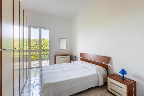 a bedroom with a bed and a sliding glass door at House&Villas - Residence Miramare in Avola