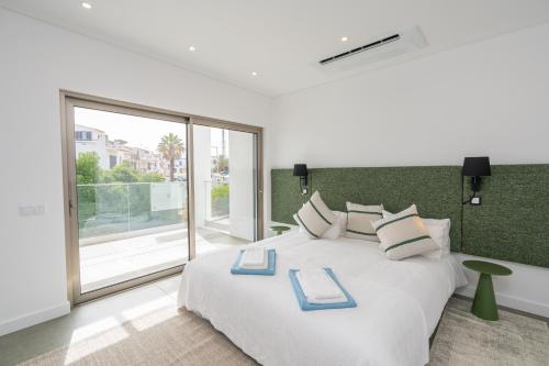 a bedroom with a white bed with a large window at Villa Bazaruto in Lagos