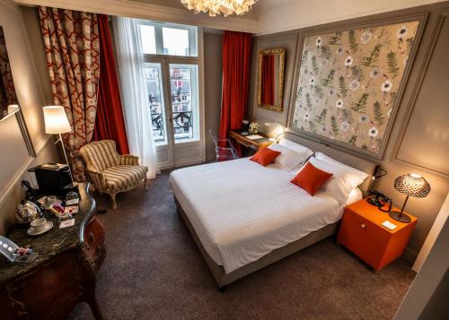 a hotel room with a bed and a chair at Grand Hotel Bellevue - Grand Place in Lille