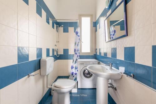 a blue and white bathroom with a toilet and sink at House&Villas - Residence Miramare in Avola