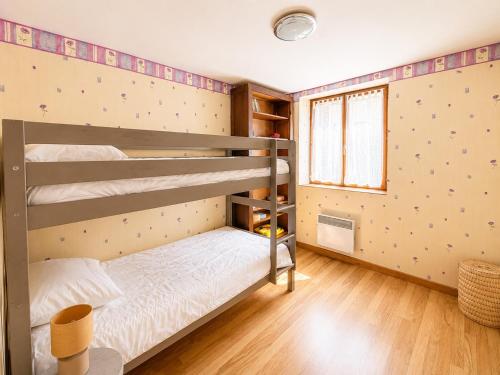 a bedroom with two bunk beds and a window at Le petit Chai in Chémery