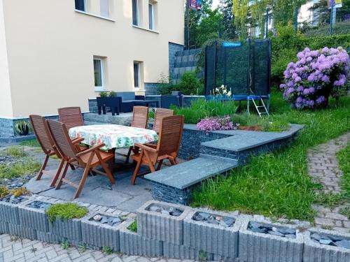 a patio with a table and chairs and flowers at Ferienwohnung mit Garten und Spielplatz in Klingenthal