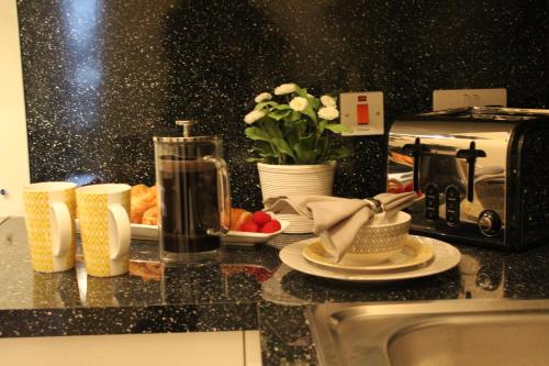 a kitchen counter with a toaster and a plate of food at The Llangollen - Berwyn House in Wrexham