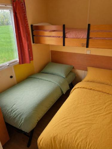 a room with two bunk beds and a window at Chez Elisa et Fabien in Canet-de-Salars