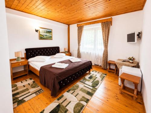 a hotel room with a bed and a window at Pensiunea Sub Piatră in Sălciua de Sus