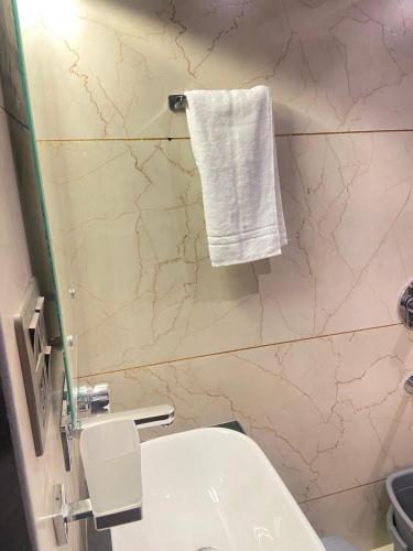 a bathroom with a white towel hanging on a wall at Vakil Villa in Srinagar