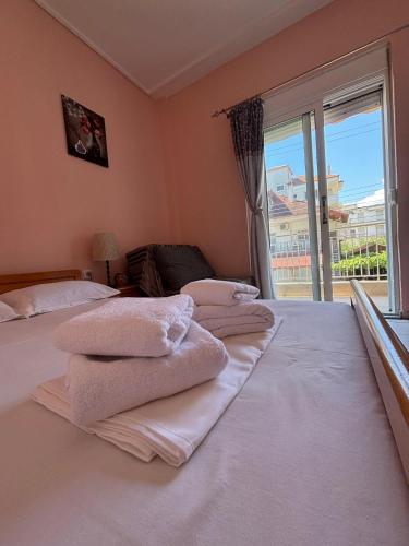 a room with three pillows on a bed with a window at Pieria Paralia Apartment in Paralia Katerinis