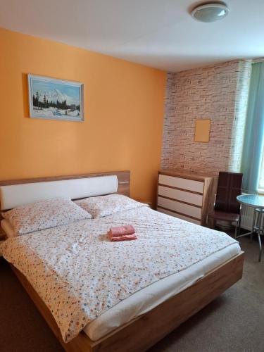 a bedroom with a bed with a pink towel on it at Privát Čujová in Hrabušice