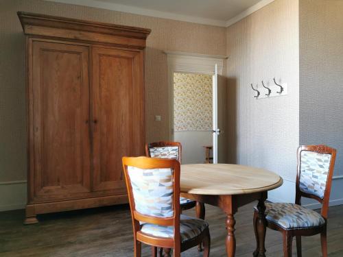 a kitchen with a wooden table and chairs at Fleurs et Abeilles in Faye-lʼAbbesse