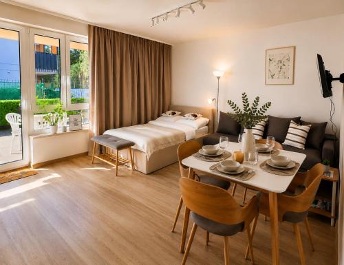 a hotel room with a bed and a table and chairs at Augustowskie Apartamenty Blisko Jezior i Lasów oraz Bezpłatny parking in Augustów