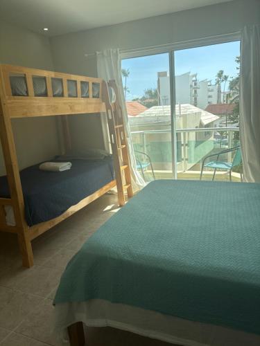 a bedroom with a bunk bed and a balcony at Yara Beach in Punta Cana