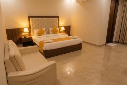 a hotel room with two beds and a couch at Hotel Rangoli - 10 min from Palsana chowk in Navsāri
